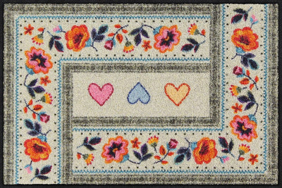 Salonloewe Fußmatte mit drei Herzen und floralem Boho-Muster auf beigem Hintergrund